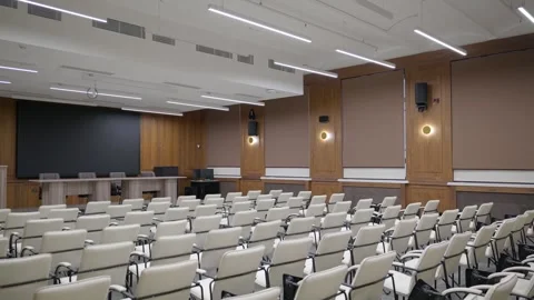 Modern empty classroom, lecture hall, with white chairs and brown walls Stock Footage 302473599