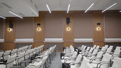 Modern empty classroom, lecture hall, with white chairs and brown walls Stock Footage 302473606
