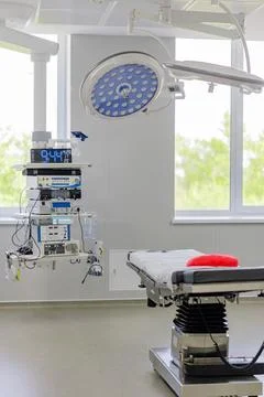 Modern empty operating room with surgical equipment and medical bed Stock Photos