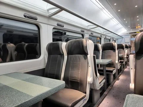 Modern empty train carriage interior with tables Stock Photos