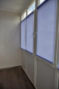 Modern enclosed balcony interior with roller blinds. Photos