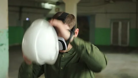 Modern engineer wearing virtual reality glasses puts a helmet on his head Stock Footage 152755257