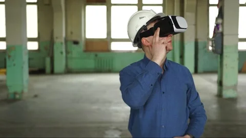 A modern engineer wearing virtual reality glasses inspects a construction site Stock Footage 152755583