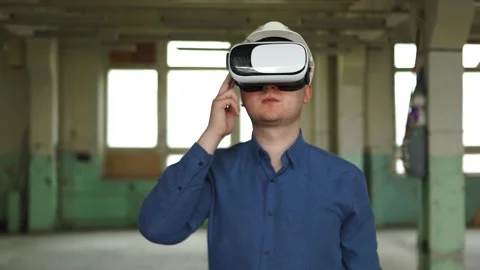 A modern engineer wearing virtual reality glasses inspects a construction site Stock Footage 152755897