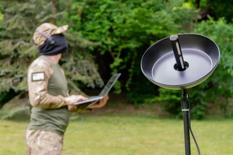 Modern espionage techniques: a military man with equipment in camouflage in t Фото