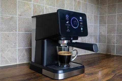 Modern espresso machine with glowing touch screen display brewing hot coffee Stock Photos