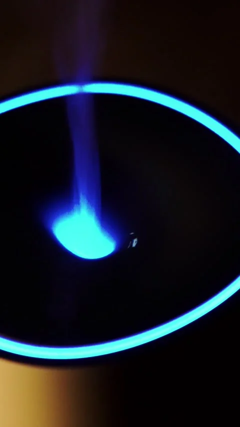 Modern essential oil diffuser releasing gentle mist with glowing blue neon .. Stock Footage 348148507