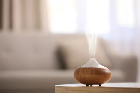 Modern essential oil diffuser on table indoors. Space for text Stock Photos