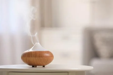 Modern essential oil diffuser on table indoors. Space for text Stock Photos