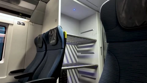 Modern Eurostar train interior featuring paired comfortable seats, overhead Vídeo Stock 330922043