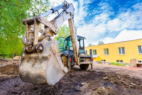 The modern excavator performs excavation work on the construction site. Front Stock Photos