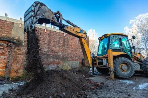 The modern excavator performs excavation work on the construction site. Front Stock Photos