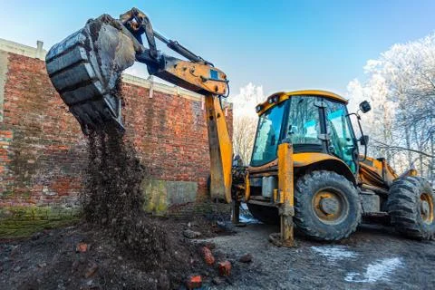 The modern excavator performs excavation work on the construction site. Front Stock Photos