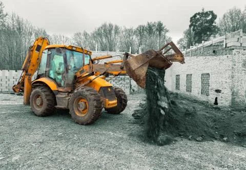 The modern excavator performs excavation work on the construction site. Front Stock Photos