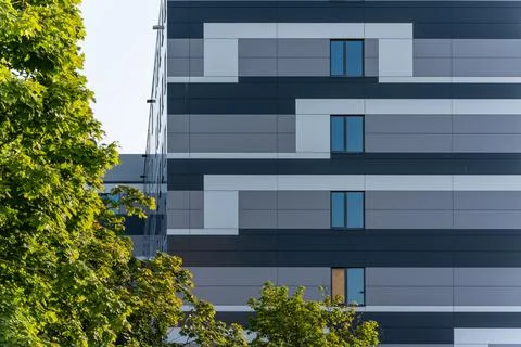 A modern facade with geometric patterns in gray and white, partially obscured by Stock Photos