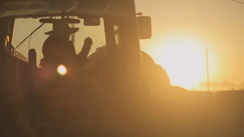 Modern Farmer in Straw Hat driving Tractor in Reverse Stock-Footage 101973039
