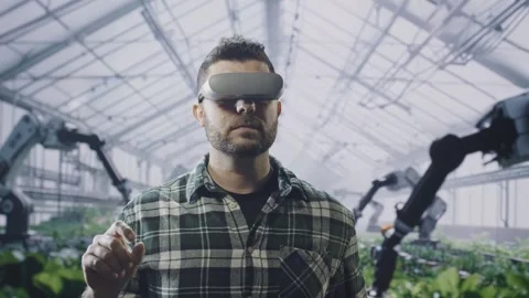 Modern Farmer Using Virtual Reality Headset In Smart Greenhouse With Robotic Stock Footage 293517575
