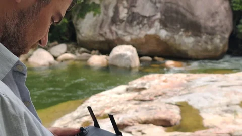 Modern filmmaking and content creation outdoors. Man uses remote control for Video stock 324410251