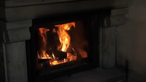 A modern fireplace burns with a bright fire flickering. This scene creates a Stock Footage 327676663