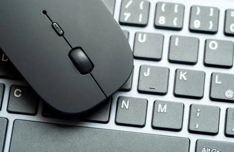 Modern flat office PC mouse laying on a computer keyboard, two objects clos.. Foto stock