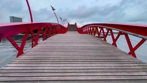 Modern footbridge Python Bridge at Eastern Docklands neighborhood of Amsterdam Stock Photos