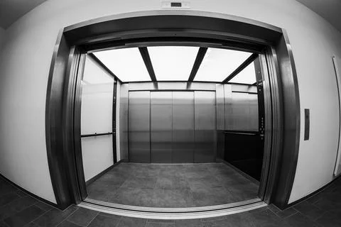 Modern freight elevator with open doors in fisheye perspective. Stock Photos