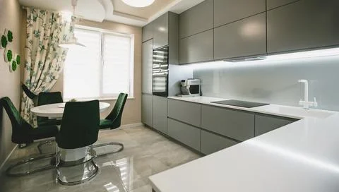 Modern fully fitted kitchen with kitchen appliances in grey green and white Stock Photos