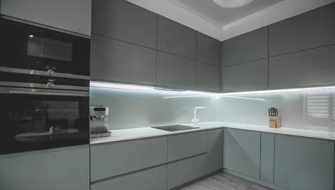 Modern fully fitted kitchen with kitchen appliances in grey and white Stock Photos