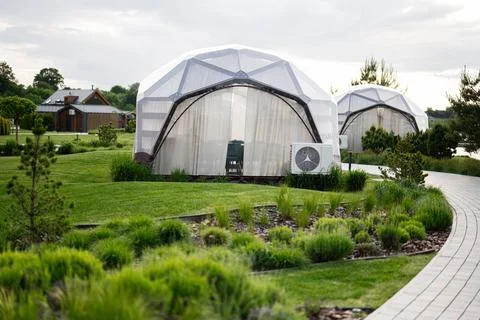 Modern geodesic dome accommodations in a serene greenery-filled resort settin Stock Photos