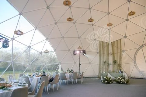Modern geodesic dome interior with elegant dining setup and decor Stock Photos