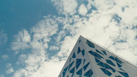 Modern Geometric Building Corner Against Blue Sky With Scattered Clouds Stock Footage 338182397