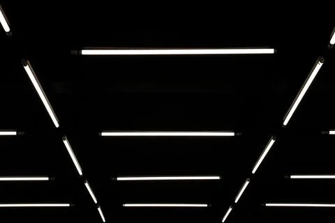 Modern geometric pattern LED linear lights installation on a black ceiling Foto stock