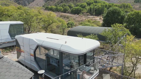 Modern glamping site with pool, lounge chairs, and curved cabin. Stock Footage 319018710