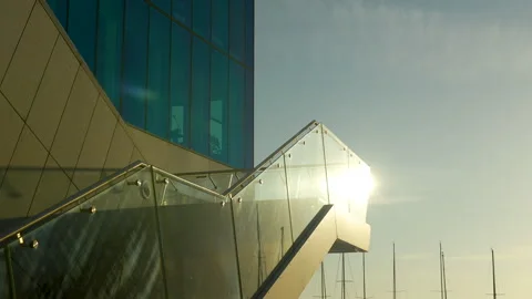 Modern glass building with angular features at sunset, reflection and Vídeos de archivo 255628515