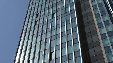 Modern glass building facade with vertical fins against blue sky Stock Footage 331582256