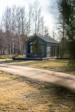 Modern glass cabin on platform in leafless birch grove, off season Stock Photos