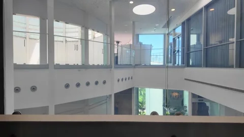 Modern Glass Elevator Moving Through Office Building Interior with Atrium View Stock Footage 343322468