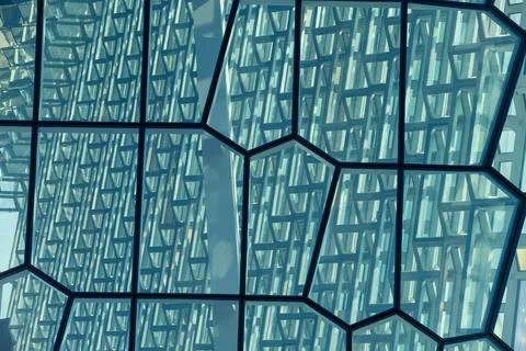 Modern glass facade with geometric patterns reflecting sunlight Stock Photos