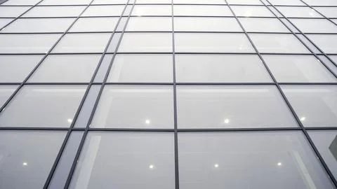 Modern glass facade with grid pattern and interior lights Stock Photos