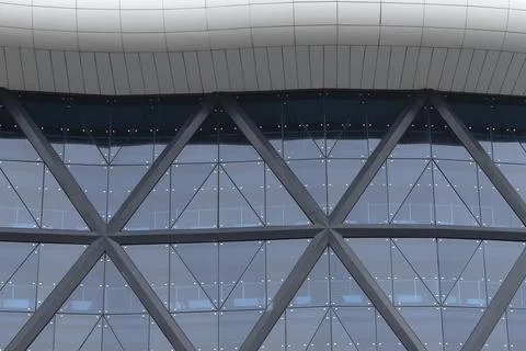 Modern glass facade with triangular structure and reflective windows. Foto stock