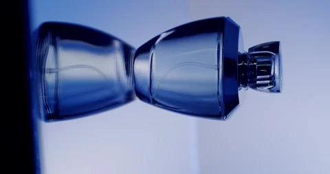 Modern Glass Perfume Bottle With Elegant Design Against Blue Background Vidéo 342806149