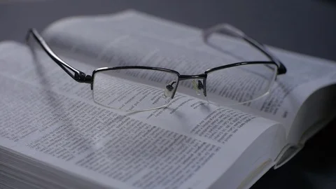 Modern glasses on the book. Camera closeup. Shallow depth of field. Stock Footage 73462032