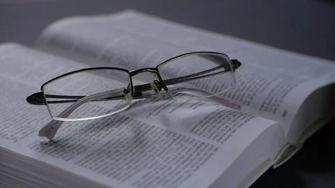 Modern glasses on the book. Camera closeup. Shallow depth of field. Stock Footage 73462053