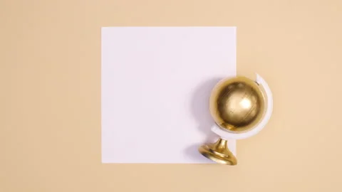 Modern gold globe rotating on paper card note on nude background. Stop motion Stock Footage 150665082