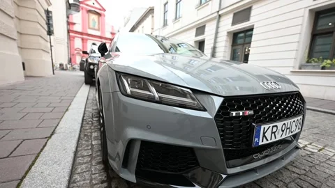 A Modern Gray Audi TT RS Sportscar Elegantly Parked on a Historic Street in.. Stock Footage 313676670