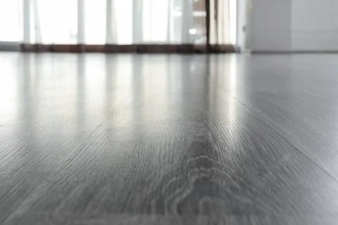 Modern gray laminate flooring with window light reflection, home interior des Stock Photos