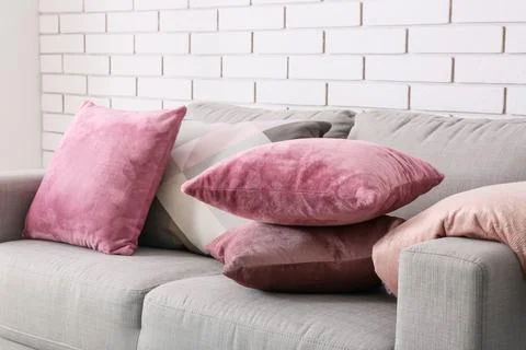 Modern gray sofa with assorted pink and geometric patterned throw pillows in  Stock Photos