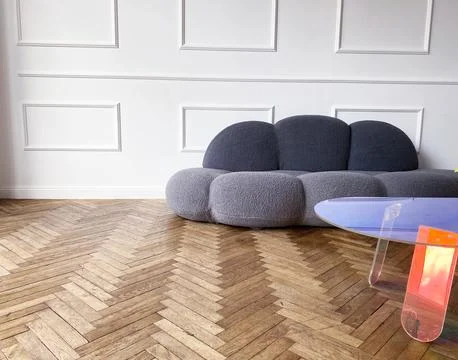 Modern gray sofa with rounded edges positioned in a minimalist interior Foto stock