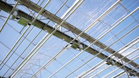 Modern greenhouse ceiling with hydrating system. Clear blue sky on the Stock Footage 99362570