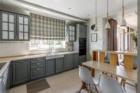 Modern Grey Kitchen with Wooden Elements and Dining Space Stock Photos